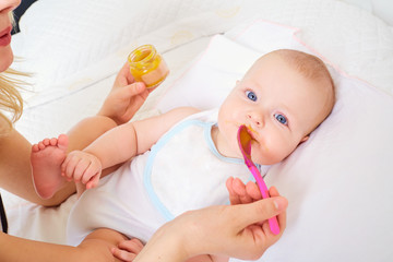 Child Feeding. Mother baby food from a spoon