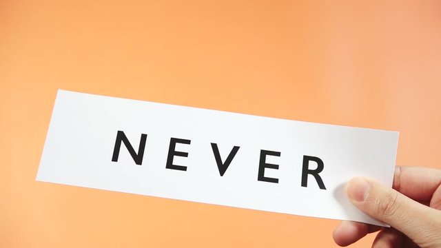 Woman cutting word NEVER to read EVER. Female hand using scissor to express motivation and encouragement objective. Concept of think positive, self belief and success of achievement