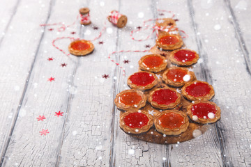 Christmas Baking Cookies with Marmalade on White Wooden Background with crackling effect.Holiday card.Copy space.Drawn Snowfall.selective focus .