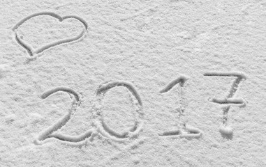 Merry Christmas and Happy New Year. Snowy background with hearts and the inscription 2017