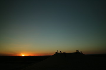 Fototapeta premium jovens assistindo o pôr do sol do alto de um monte.