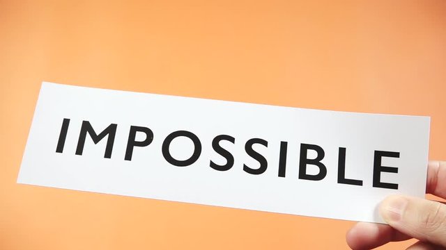 Woman cutting word IMPOSSIBLE to read POSSIBLE.  Female hand using scissor to express motivation and encouragement objective. Concept of think positive, self belief and success of achievement