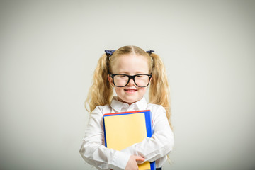 Schoolgirl in glasses reaching toward the school.