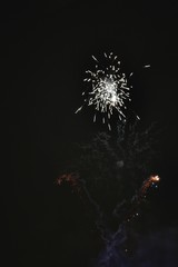 Shiny natural fireworks on dark black sky background with a litt