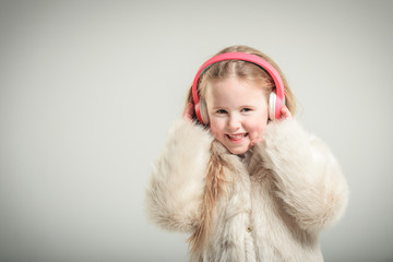 Party girl in pink fur coat and headphones.