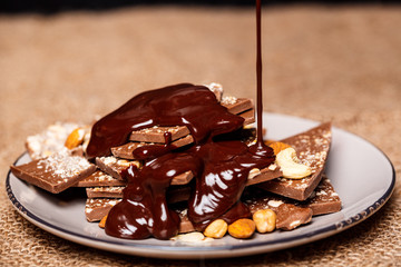 Hot chocolate pouring on candies in white plate  sackcloth.