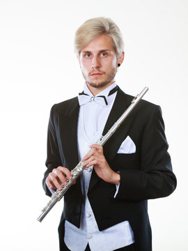 Male flutist wearing tailcoat holds flute