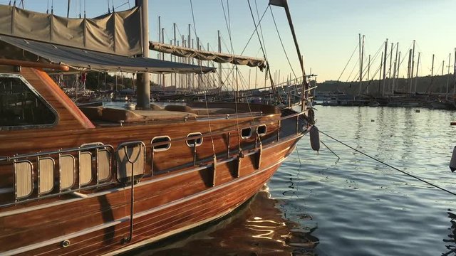Traditional gulet sailboats moored in the marina at sunset in the tourist resort town of Bodrum, Turkey