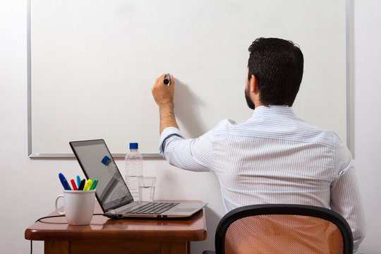 Home office, man writing in white board
