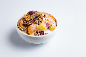 granola with ftuits salad on the white background.