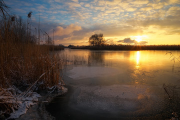 Winter landscape with sunset sky and frozen river. Daybreak