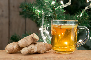 Ginger tea in a cup on wooden background