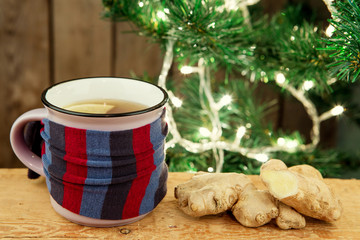 Ginger tea in a cup on wooden background