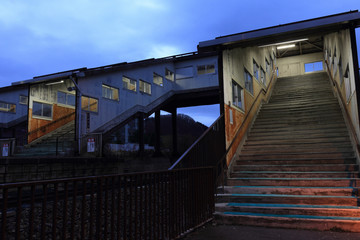 田舎の駅の風景　早朝の古い階段と連絡橋