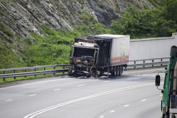 Fototapeta na wymiar Burnt truck on the highway. The car after the fire