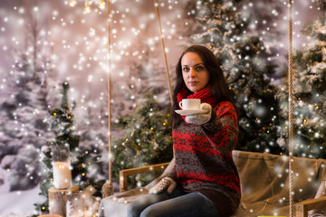 Woman sitting on a swing with a blanket under the flashlights an