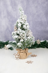 Christmas, New Year greeting card. Winter, Christmas, New Year decoration – pine tree/spruce  with wooden snowflakes. on colorful background. Pine tree garland. Place for text, copy space.