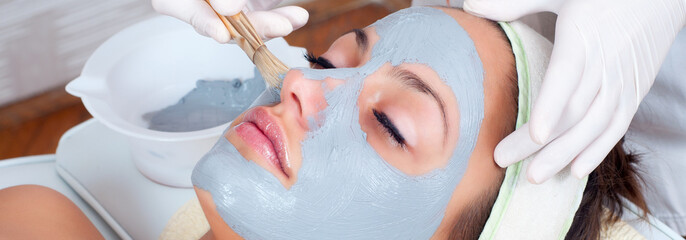 Girl with facial mask lying in beauty health spa center - obrazy, fototapety, plakaty