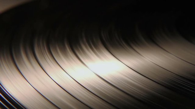 Macro Closeup Shot Of A Vinyl Record Disc Spinning Around. You can see the grooves on the disc as it spins. 
