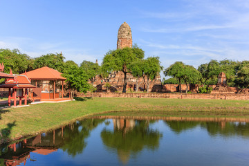 Young woman praying to giant reclining buddha statue at Wat Lokayasutharam, Ayutthaya Historical Park, Ayutthaya, Thailand.