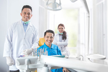 Dentist smiling with male patient in dental clinic