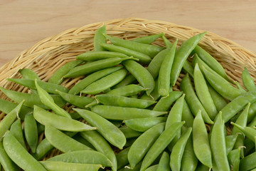 Close up of Green snap beans in wood basket in preparation for removing strings