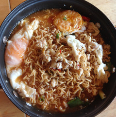 Instant noodles with minced pork and boiled egg in black bowl