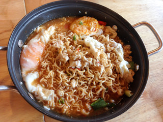 Instant noodles with minced pork and boiled egg in black bowl