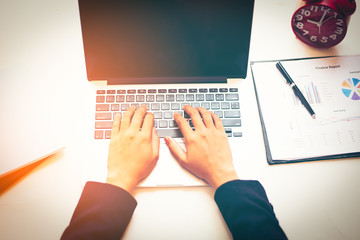 Young woman sitting at the desk with instruments, plan and laptop