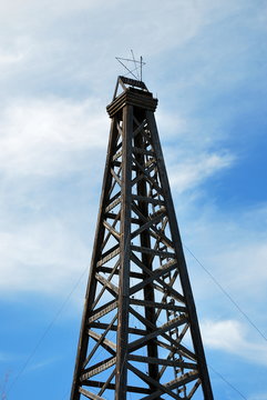 Old Wooden Oil Rig Displayed Outdoors.