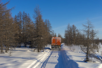 Winter landscape with forest, snow and ice road and SUV truck.