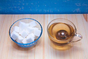 glass mug with tea and a glass sugar bowl