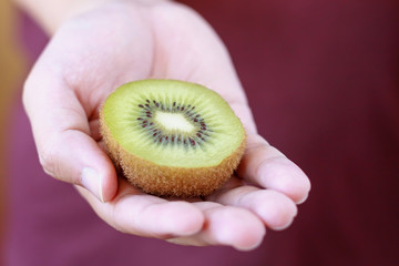 holding fresh kiwi fruit