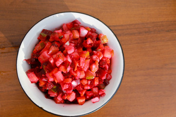 Russian beet salad vinaigrette in rustic bowl on wooden table