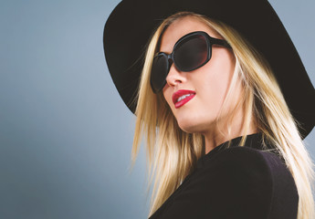 Fototapeta premium Beautiful young blonde woman in a black coat