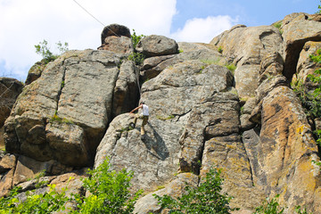 Man climber climbing up on a rock