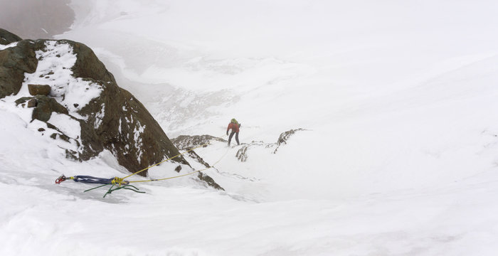 a mountain climber retreating from the summit in the high peaks of the Cordillera Blanca in Peru during a snow storm