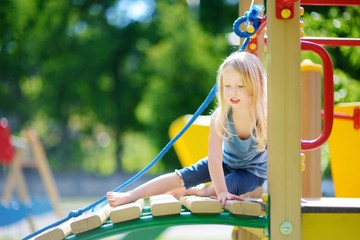 Fototapeta na wymiar Cute little girl having fun on a playground
