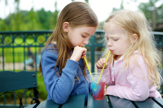 Two Cute Little Sisters Drinking Frozen Slushie Drink