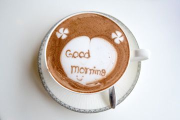 a cup of hot Chocolate with word "good morning" on white table background. top view.