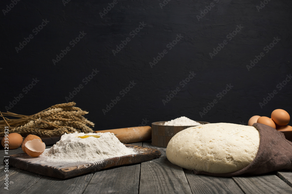 Poster fresh dough with flour and eggs on wooden table