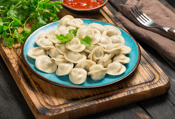 Dumplings with meat close up with sauce and parsley