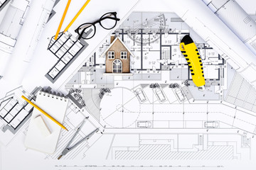 Construction plans with drawing Tools and House Miniature on blu
