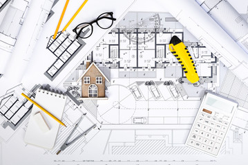 Construction plans with drawing Tools and House Miniature on blu