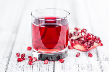 Fresh made Pomegranate juice on rustic background