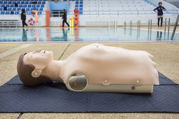 cpr dummy training nearside swimming pool blur background