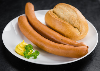 Sausages (Frankfurter) on a vintage slate slab (selective focus)