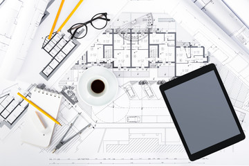 Construction plans with Tablet and drawing Tools on blueprints