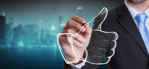 Businessman drawing thumb up illustration with a pen