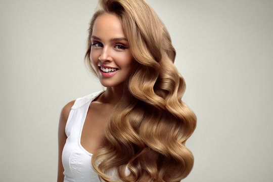 Beauty. Beautiful Woman With Long Blonde Curly Hair. Hairstyle